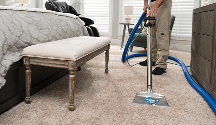 Person cleaning carpet with equipment