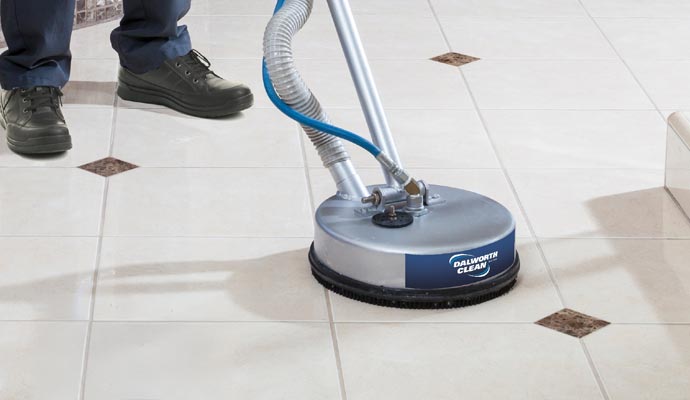 Person cleaning tile with equipment